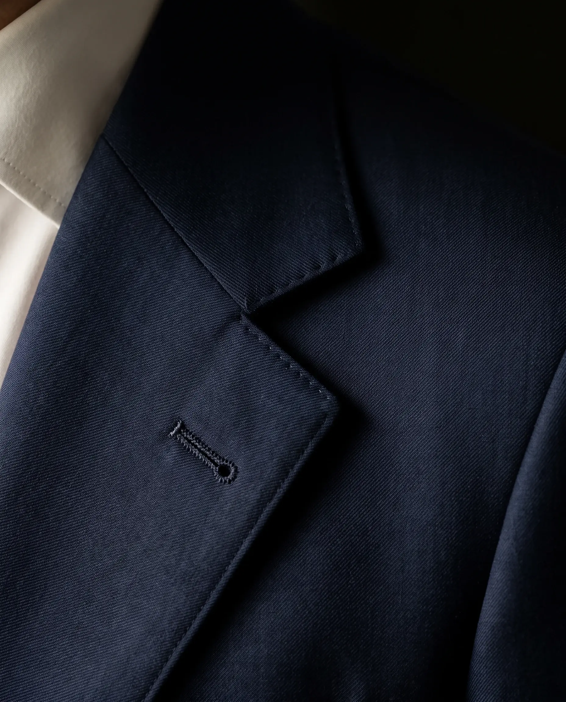 Close-up of the notch lapel and lapel buttonhole on a navy jacket