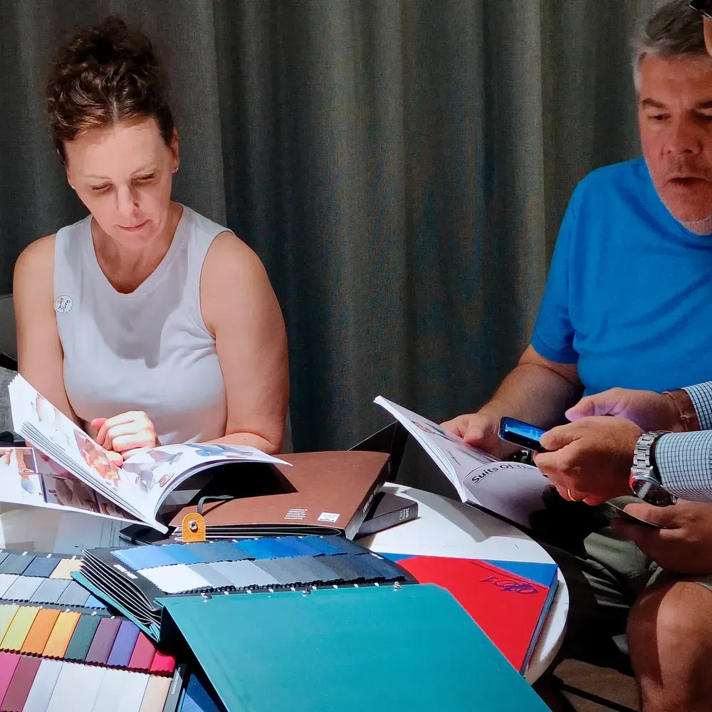 Two customers going through fabric swatch books and catalogues at a table