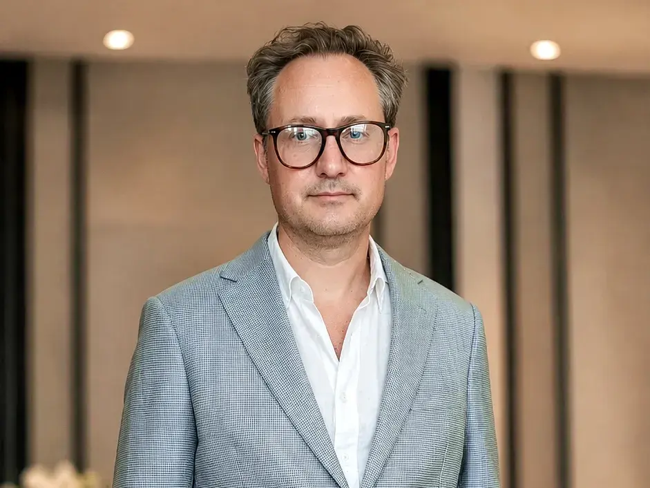 Man wearing a tailored light blue-grey linen blazer with beige trousers
