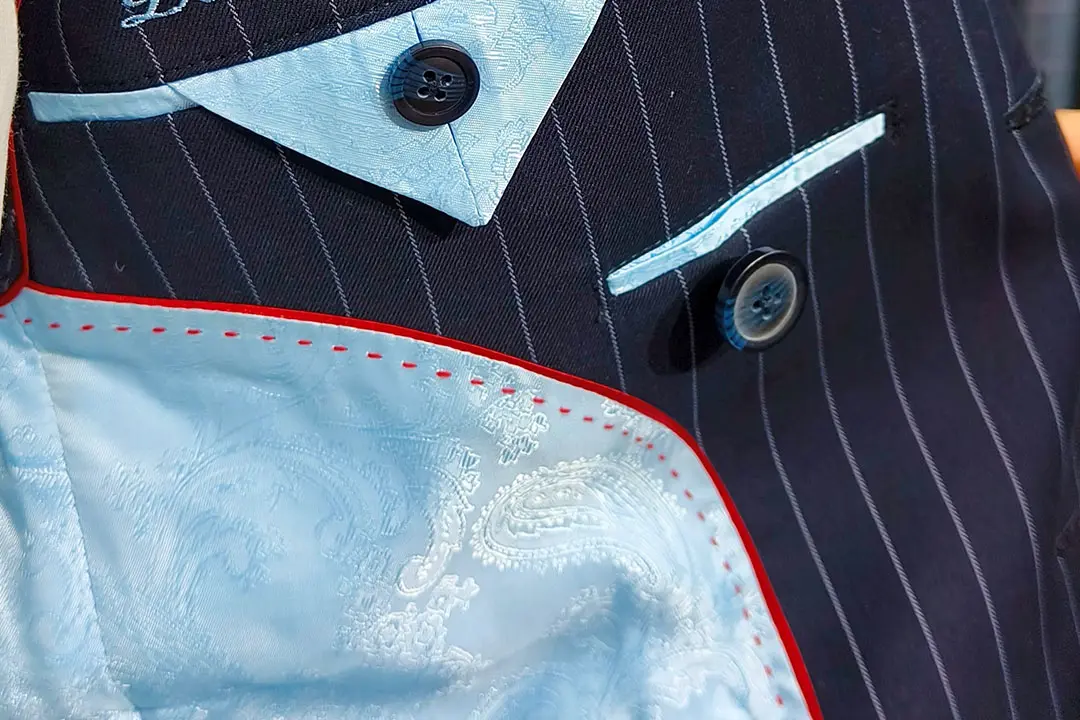 Navy pinstripe jacket with a light blue paisley jacquard lining and red contrast piping