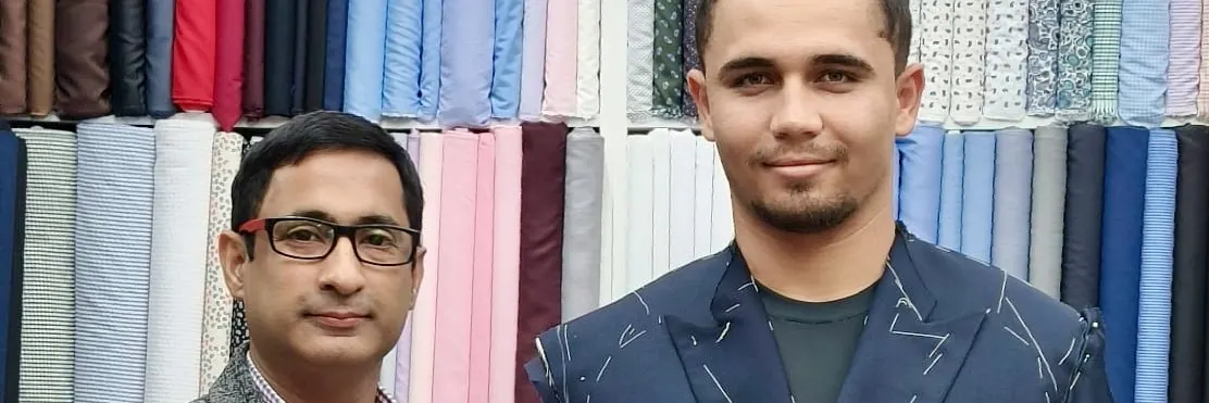 Client wearing a basted navy double-breasted jacket marked with chalk during a first fitting