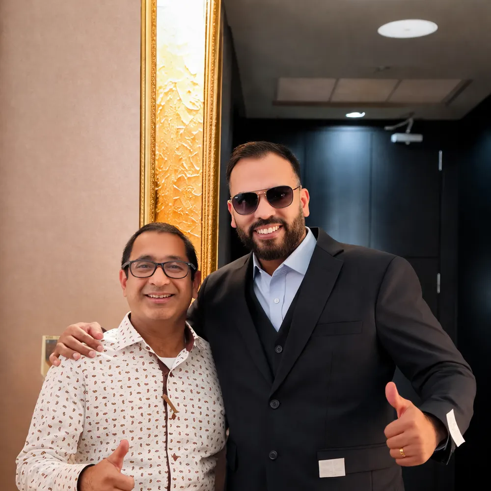 Client in a black three-piece suit posing with a tailor