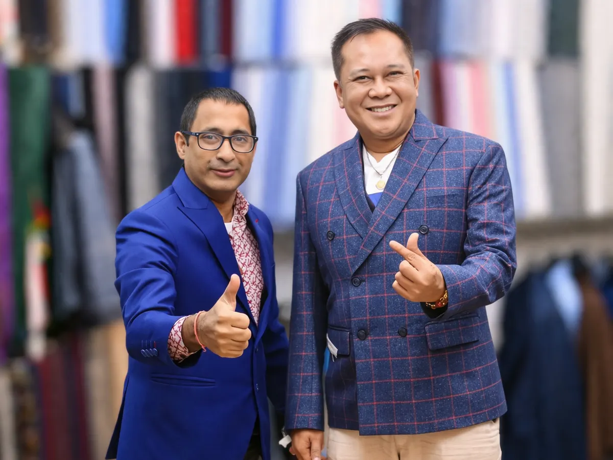 Client in a blue check double-breasted jacket beside a tailor in a blue blazer