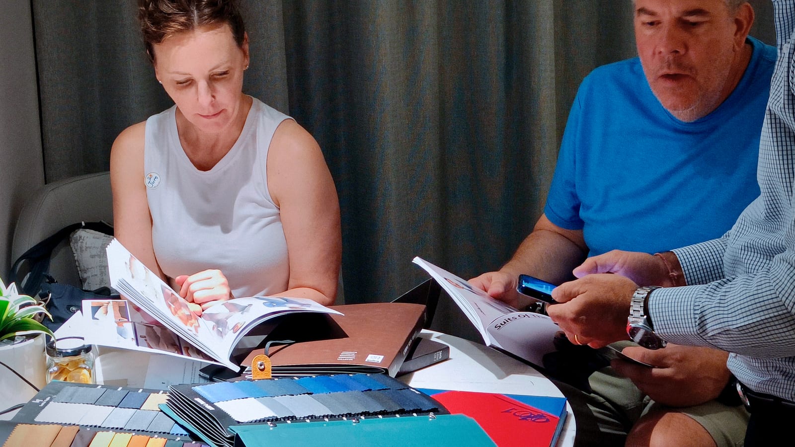 Two customers going through fabric swatch books and catalogues at a table