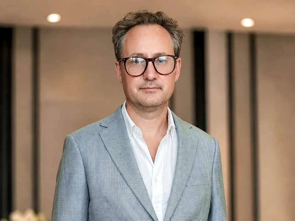 Man wearing a tailored light blue-grey linen blazer with beige trousers