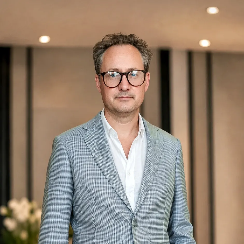 Man wearing a tailored light blue-grey linen blazer with beige trousers