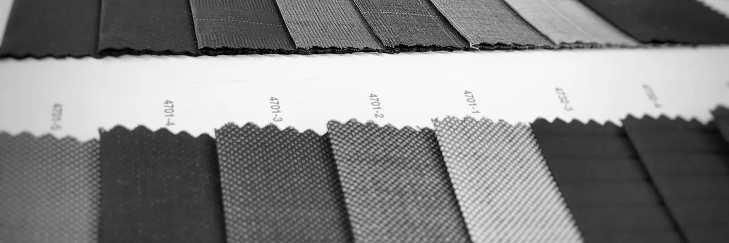 Black-and-white photo of dark suiting fabric swatches laid out in rows