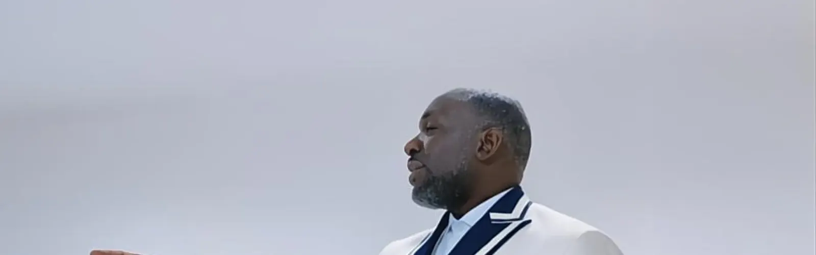 Client in a white double-breasted dinner jacket with navy piping in a bright private room